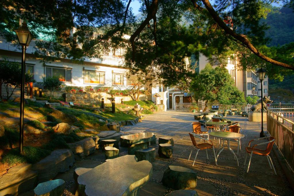 a courtyard with tables and chairs and a building at Utopia Holiday Hotel in Heping