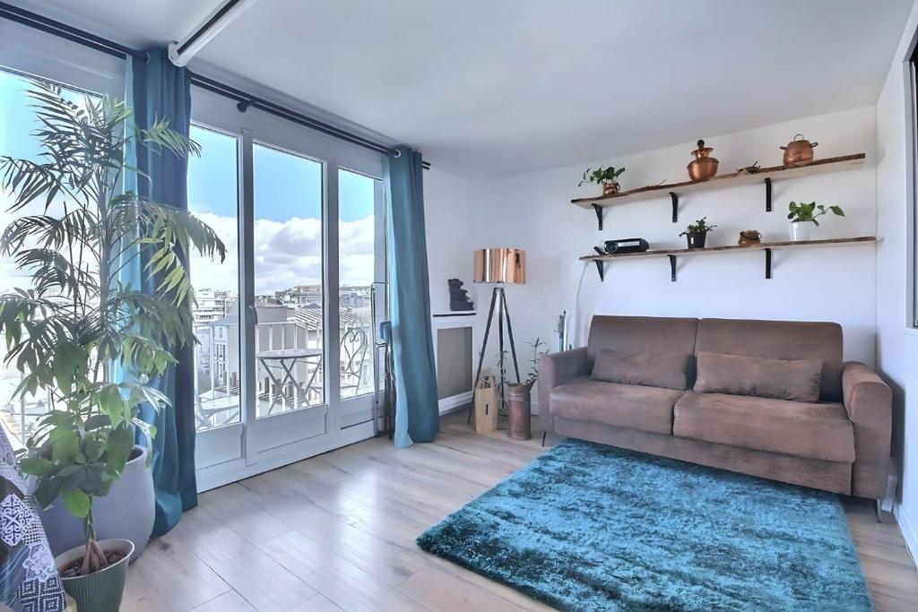 un salon avec un canapé et une grande fenêtre dans l'établissement Paradis du Canal St-Martin et Jardin Villemin, à Paris