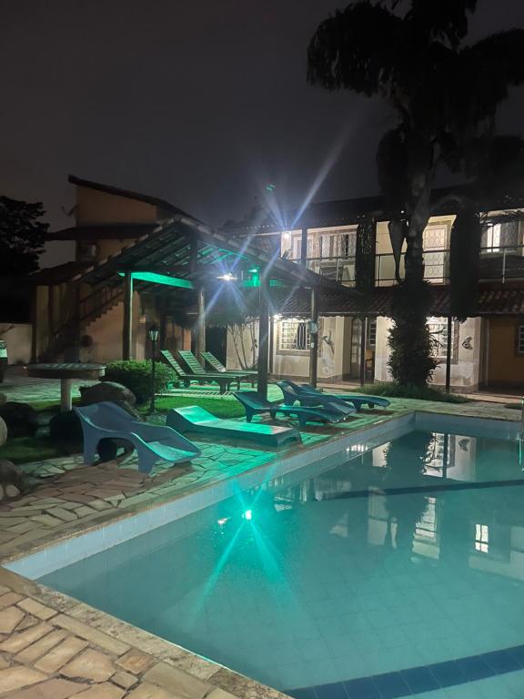 uma piscina vazia à noite com luzes em Encantu's Flats em Itatiaia