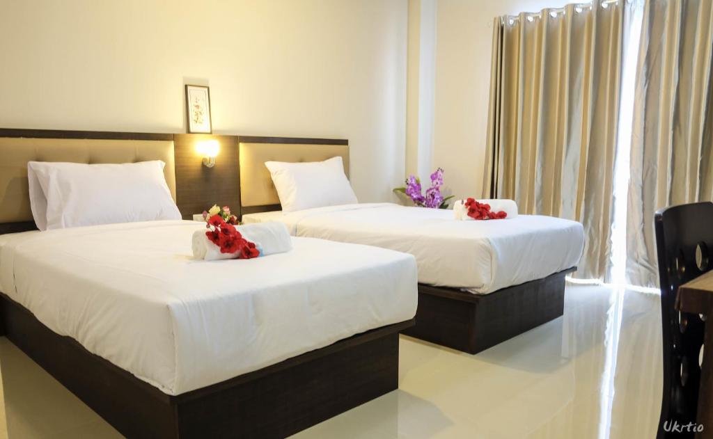Two separate beds fill a bright twin room with a curtained window or balcony door.