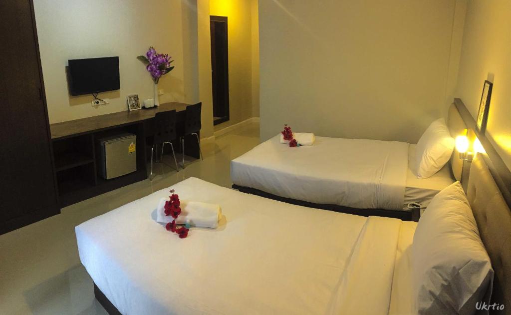 A twin room places two beds opposite a TV, desk and mini-fridge.