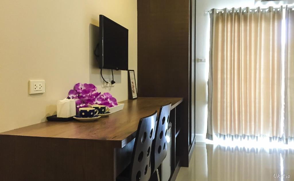 A built-in desk with two chairs occupies a bright corner beside a curtained opening.