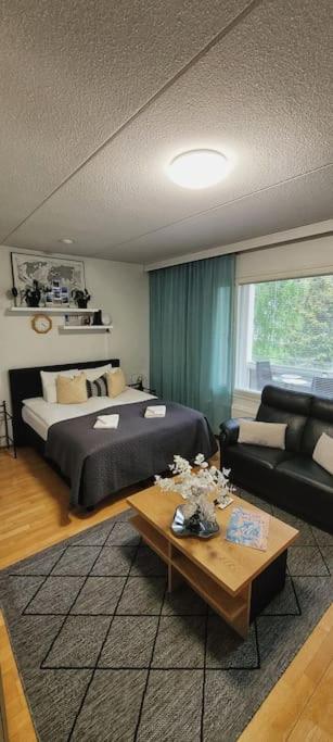 1 dormitorio con cama, sofá y mesa en Upea saunallinen asunto järvinäkymällä. en Jyväskylä
