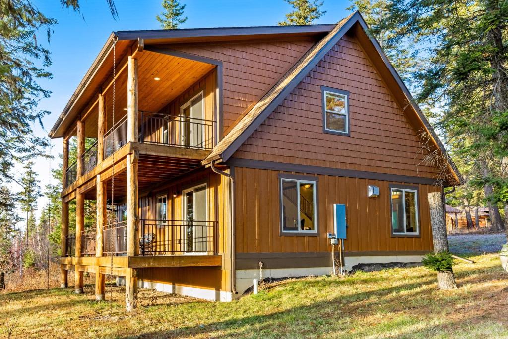 une maison entourée d'une terrasse couverte et d'une terrasse dans l'établissement Experience Montana Cabins - Lake View Luxury #7 & Dream Catcher Luxury #8, à Bigfork