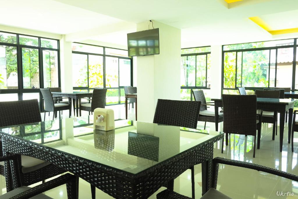 The bright dining room has glass-topped tables, woven chairs and large windows.