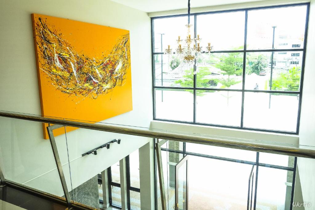 A glass-sided landing with a large abstract painting and chandelier.