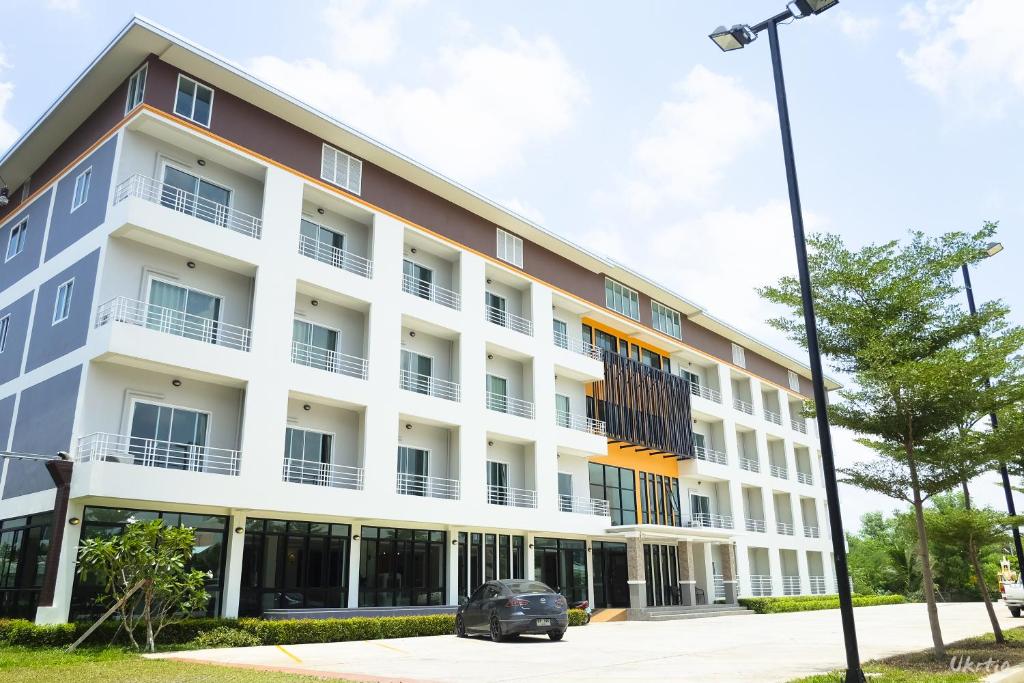 an apartment building with a car parked in front of it at The Room Mahidol Chiangmai in Chiang Mai