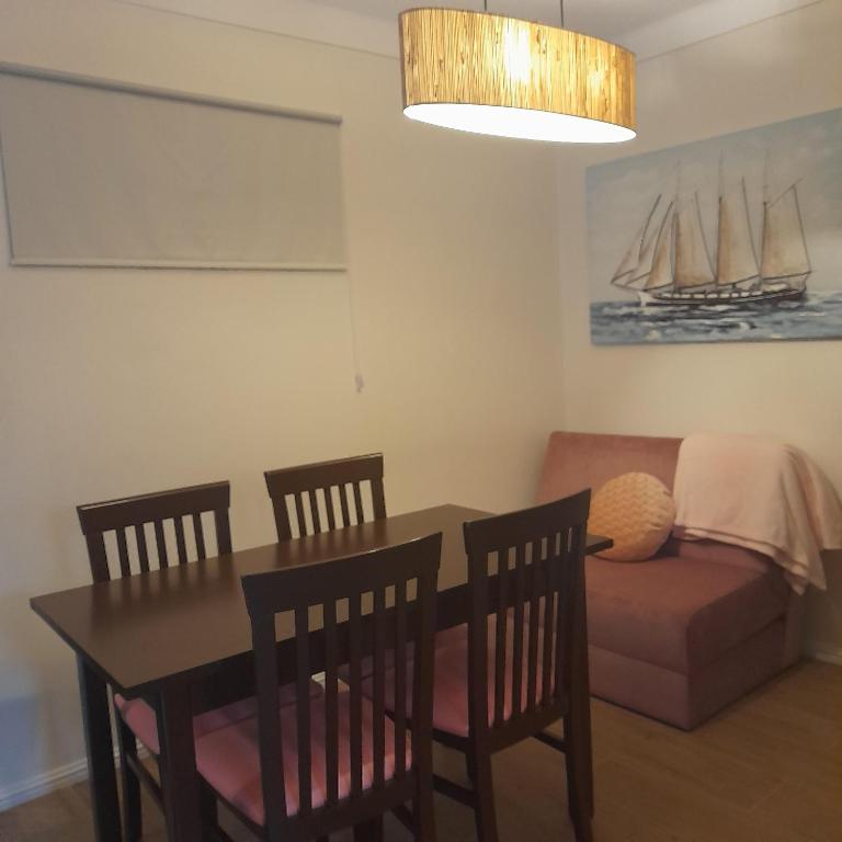 een eetkamer met een tafel, stoelen en een bank bij Brunhedo2 in Vila Boa