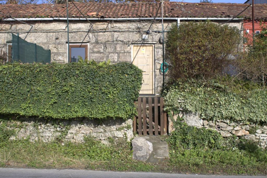 una casa con una pared de piedra y una puerta en Típica Casa de Piedra, en Santiago de Compostela