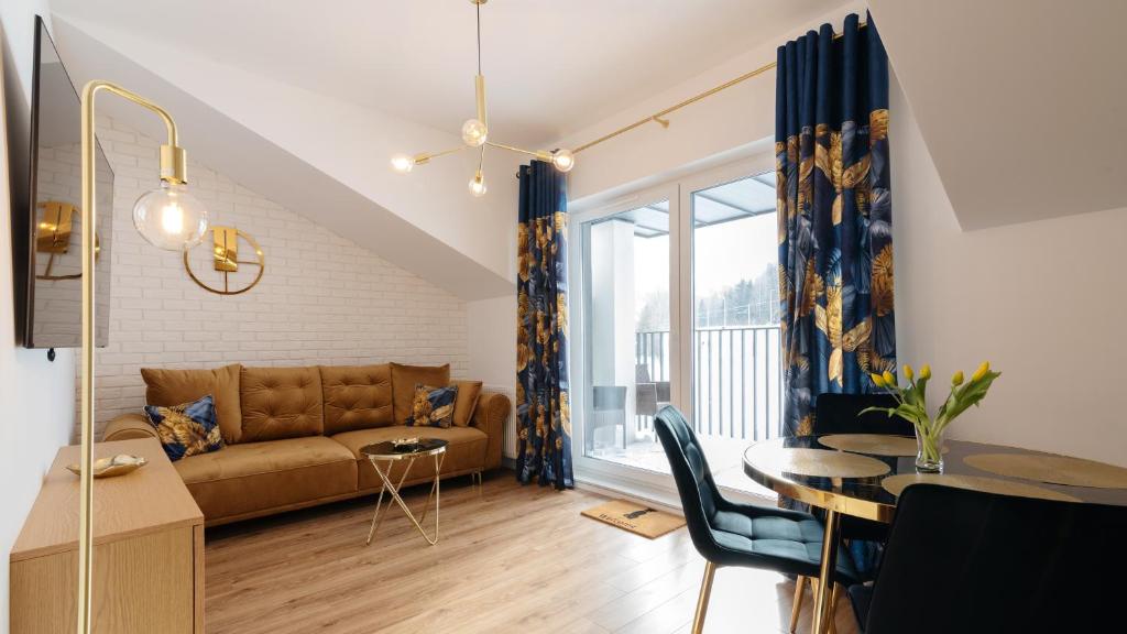ein Wohnzimmer mit einem Sofa und einem Tisch in der Unterkunft Apartament z WIDOKIEM in Wisła