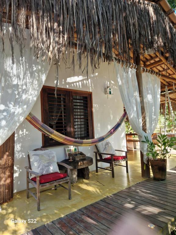 a room with a hammock and chairs in a house at Mini Casa com Jacuzzi e Piscina in Trancoso