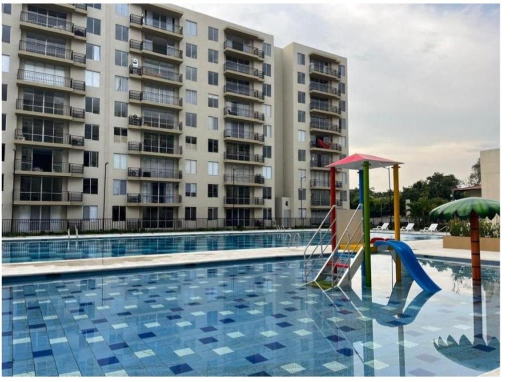 een zwembad met een speeltuin voor een gebouw bij Lindo Apartamento Amoblado ricaute in Ricaurte