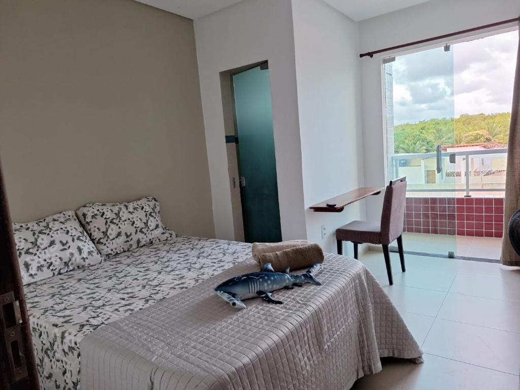 a bedroom with a bed and a desk and a window at Pousada Abreu do Una in São José da Coroa Grande