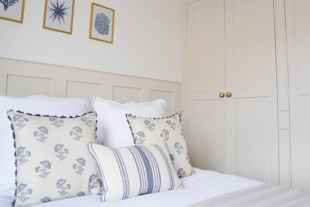 a bed with white sheets and pillows in a bedroom at Rye Harbour Cosy Cottage in Rye