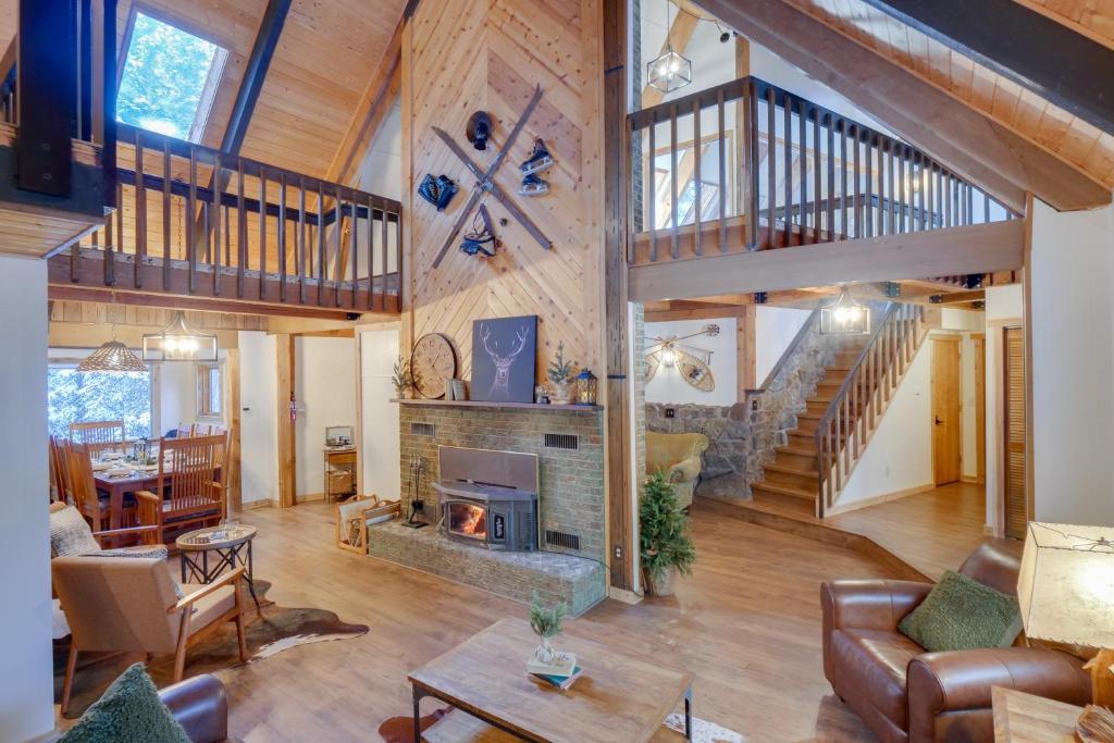 a large living room with a fireplace and a staircase at Riverside Colorado Chalet with Deck and Hot Tub in Dumont