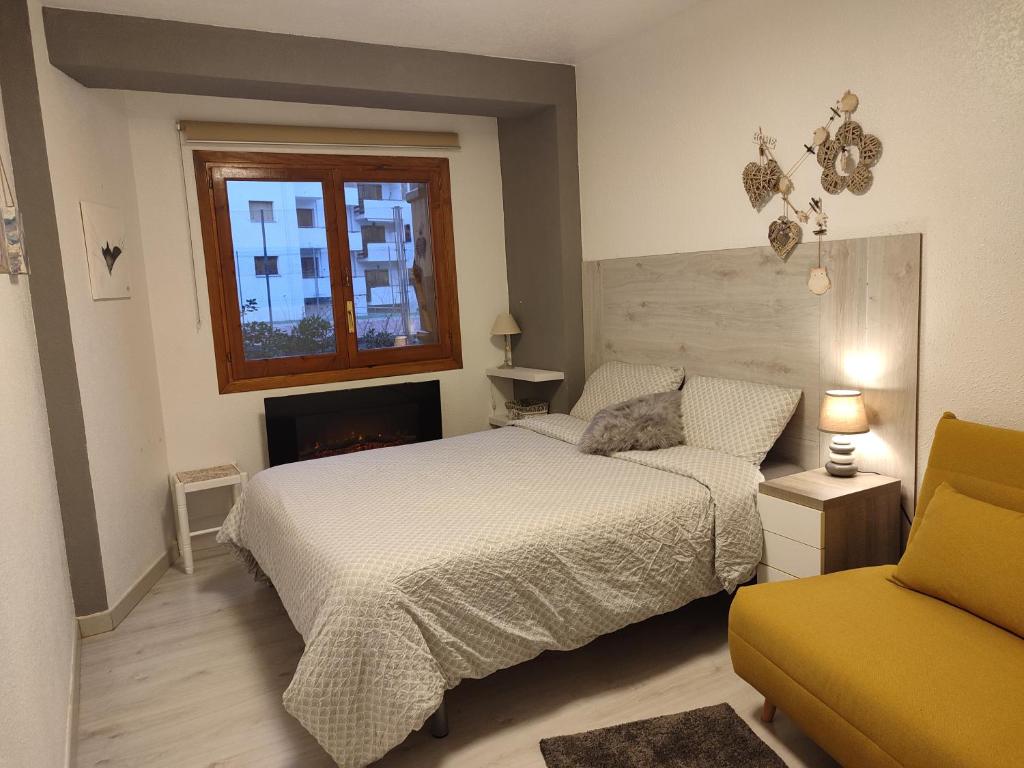 a bedroom with a bed and a couch and a window at Descanso en el pirineo in Villanúa