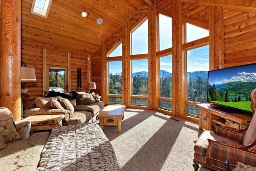 una sala de estar con TV de pantalla grande en una cabaña en Peaceful Cabin Home with Breathtaking View!, en Big Bear City