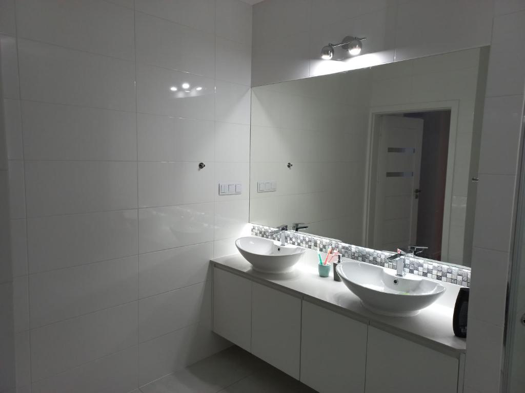 un bagno con due lavandini e un grande specchio di Apartament ANNA a Biała Podlaska