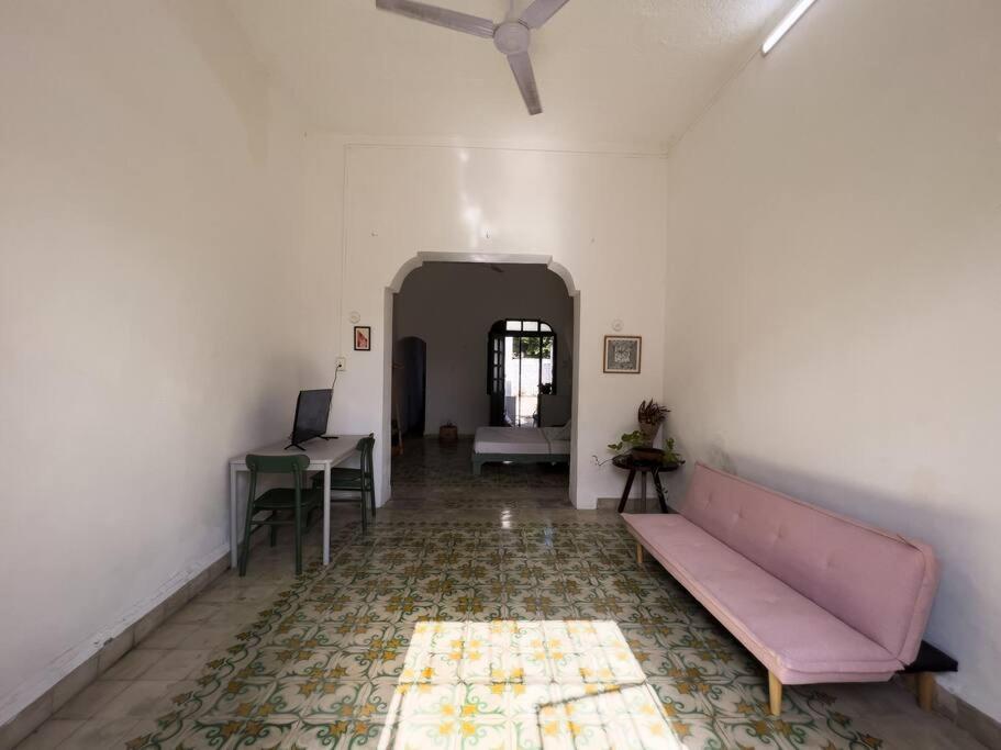 ein Wohnzimmer mit einem rosa Sofa und einem Tisch in der Unterkunft Casa yucateca ZAMA en Santiago. in Mérida
