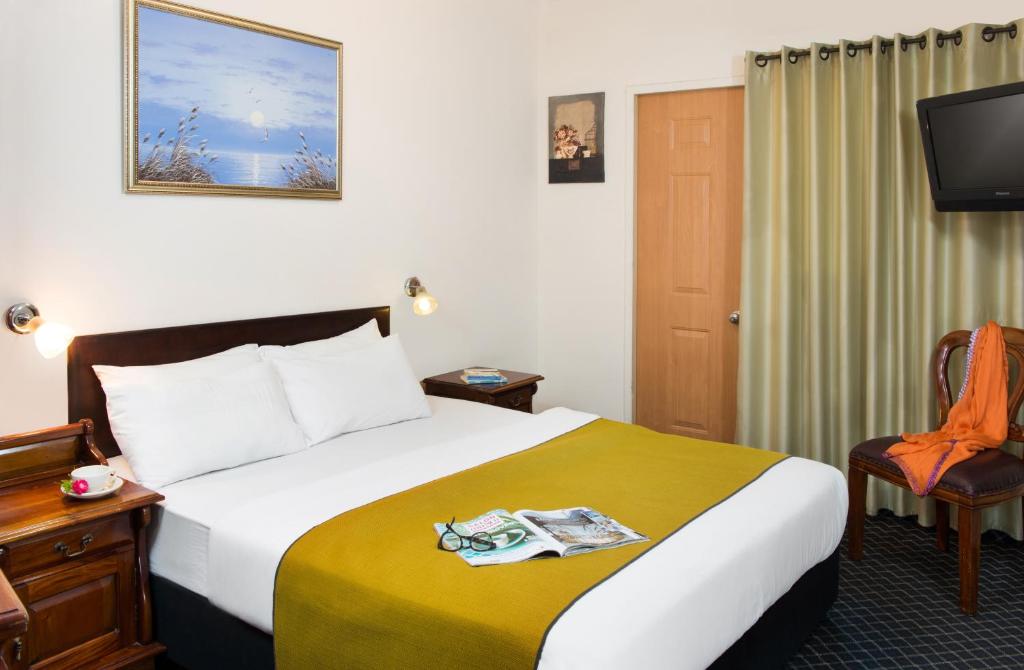 a hotel room with a bed and a tv at Sun City Hotel in Tel Aviv