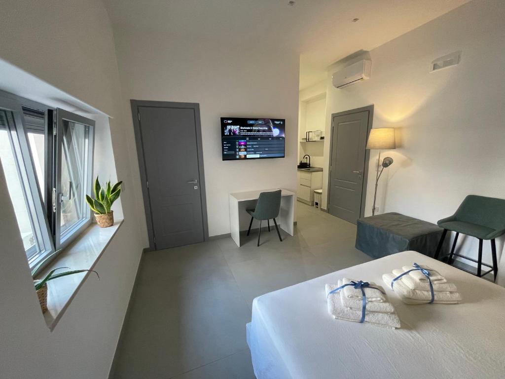 ein Schlafzimmer mit einem Bett und einem Fernseher an der Wand in der Unterkunft Casa e Bottega in Manfredonia