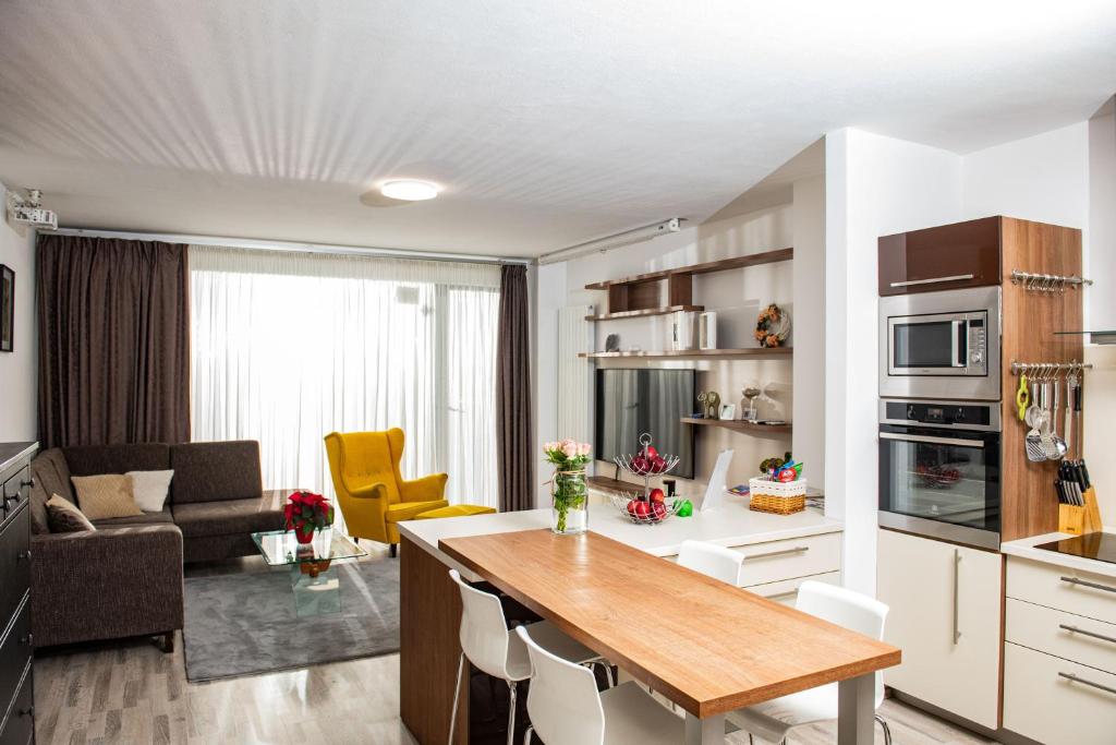 a kitchen and a living room with a table in a room at Forest Park Garden Apartment in Bratislava