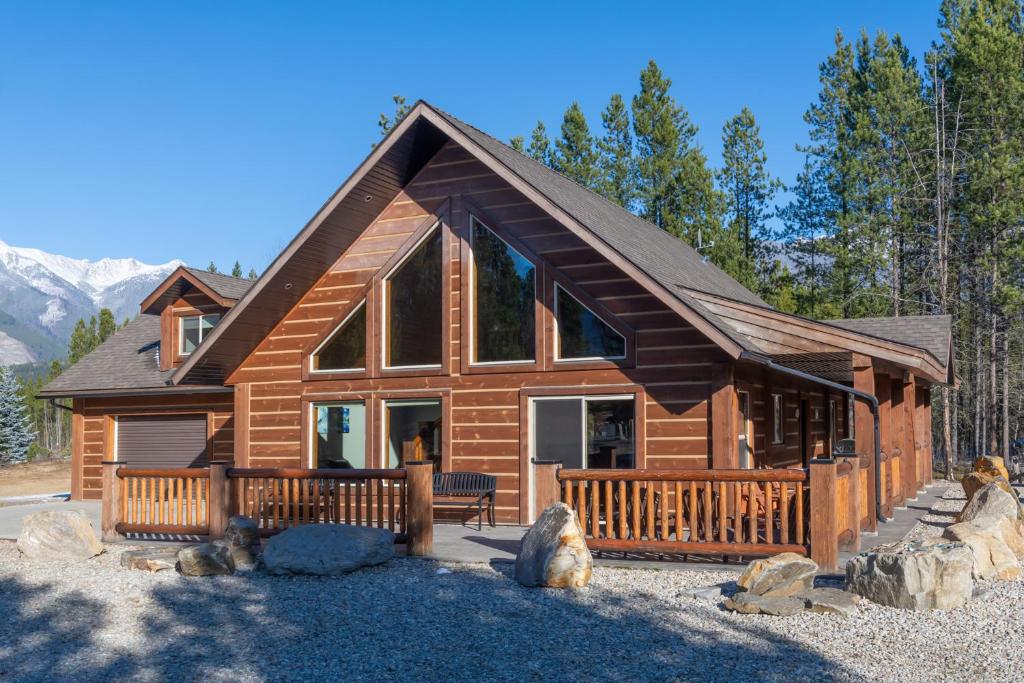 una cabaña de madera en el bosque con montañas al fondo en Cranberry, en Valemount