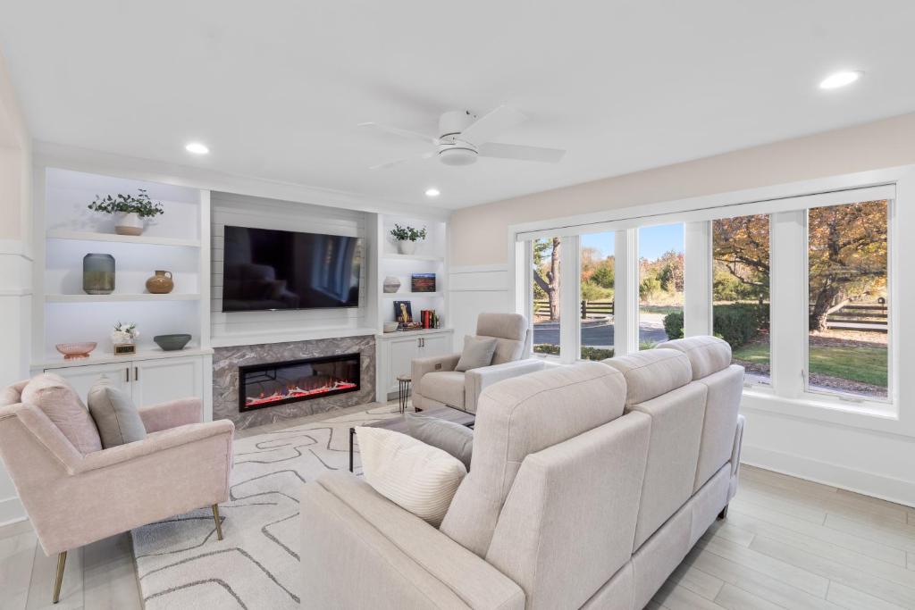 a living room with a couch and chairs and a fireplace at The Rest at Potomac Farms in Ashburn