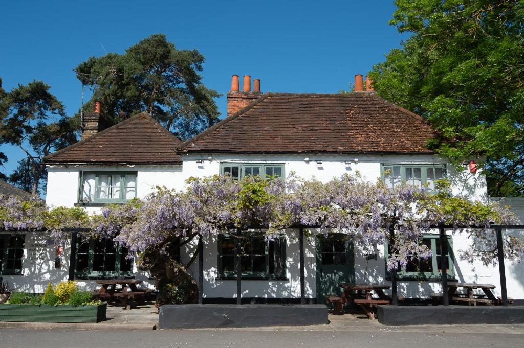 a white building with purple flowers in front of it at Chris Wheeler at The Crown Inn in Buckinghamshire