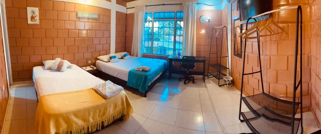 エスピナルにあるLeño Verdeのベッド2台とデスクが備わる客室です。