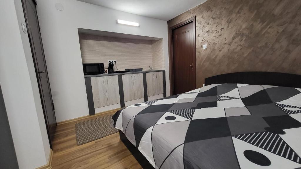 a bedroom with a black and white comforter on a bed at Casa D in Topliţa