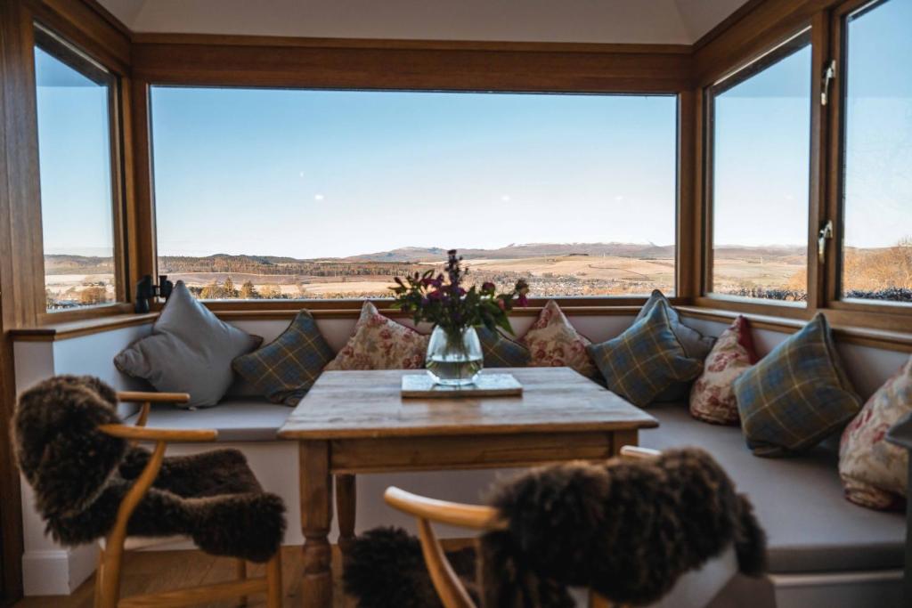 a living room with a couch and a table with pillows at Kinkell Cottage in Dingwall