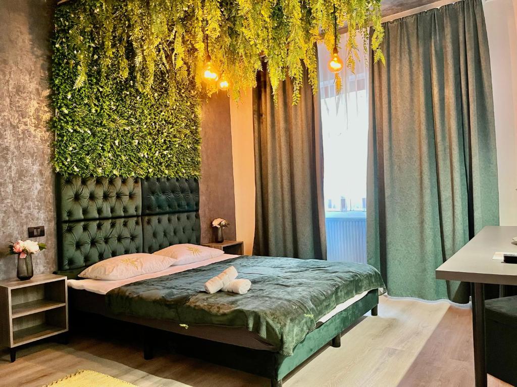 sypialnia z łóżkiem ze ścianą roślinną w obiekcie Cozy Hideout - Condo Hotel w mieście Timişoara