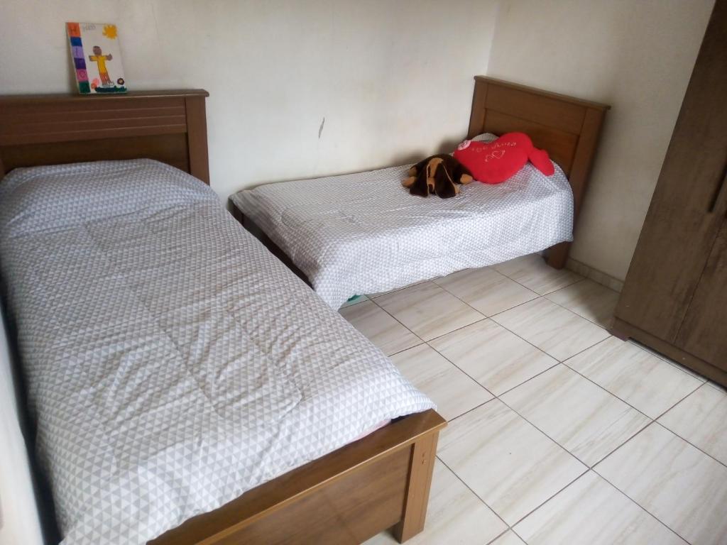Dos camas en una habitación con un perro sobre ellas en Casa de férias pura diversão., en Belo Horizonte