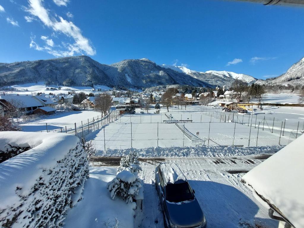 a snow covered field with mountains in the background at Apartment Ledermoos in Mauterndorf