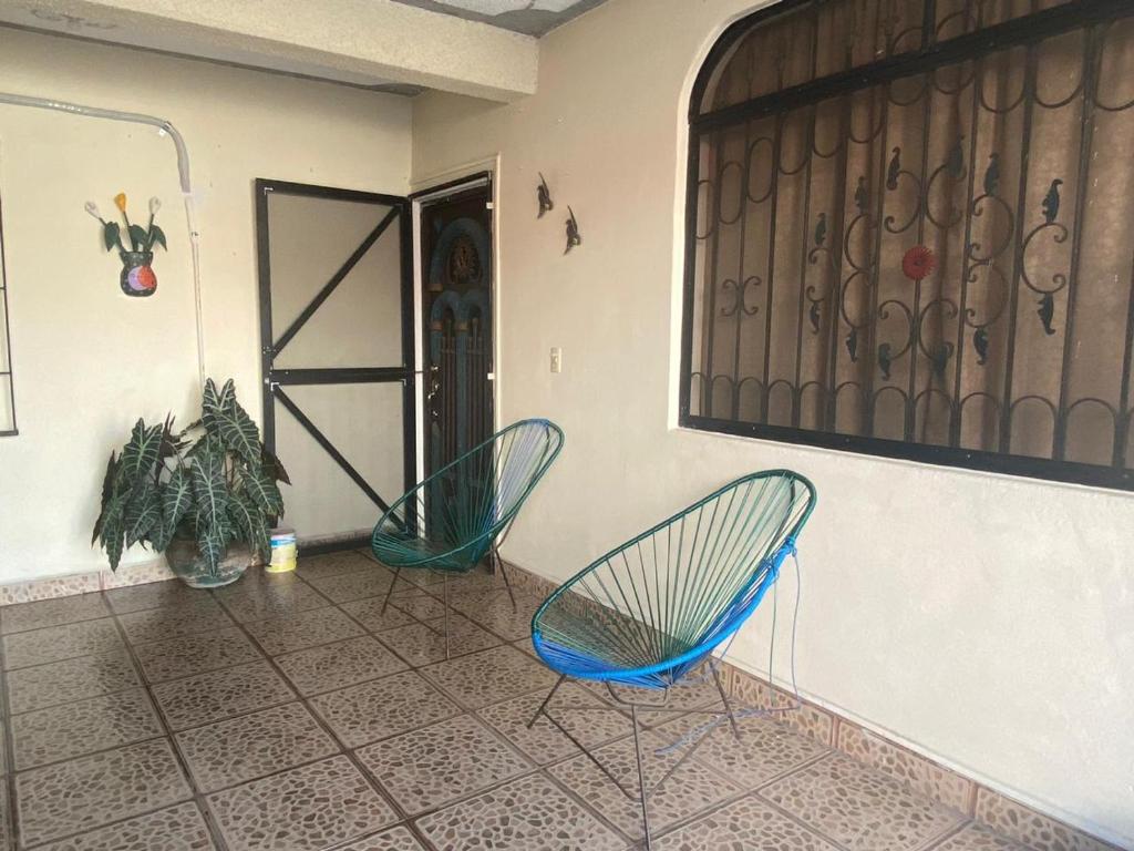 Dos sillas azules en una habitación con puerta en hermosa casa para vacacionar en Puerto Escondido