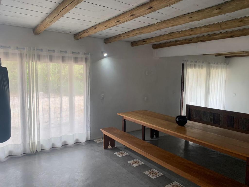 a room with a wooden bench and a window at Casa Flor da Terra in Caraíva