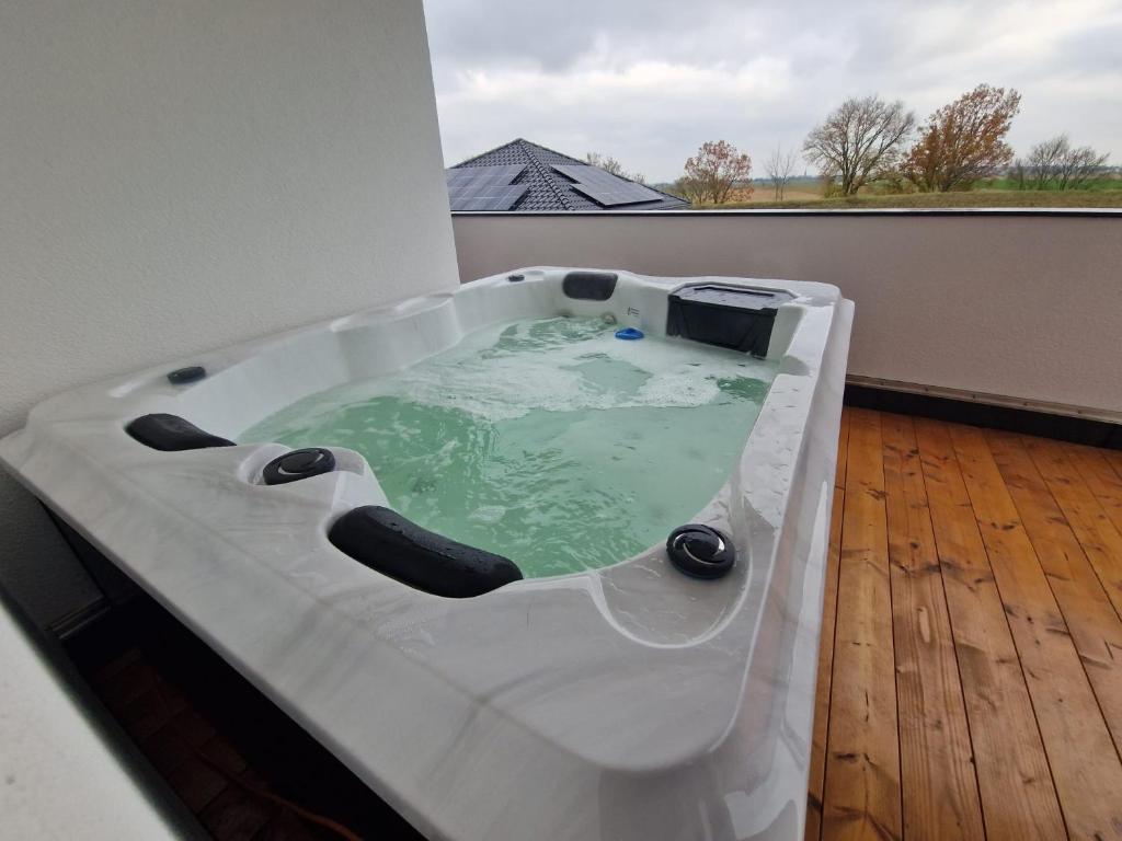 a bath tub sitting on top of a wooden floor at Apartment Nia mit Sauna und Whirlpool in Euskirchen