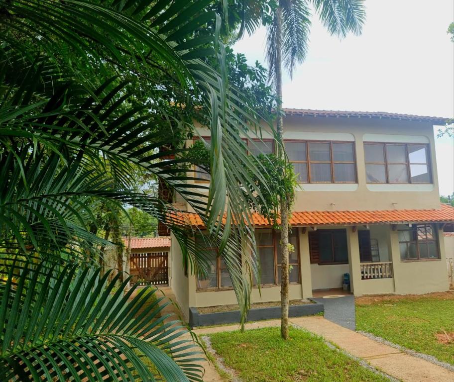 a building with a palm tree in front of it at LARA'S HOUSE in São Sebastião