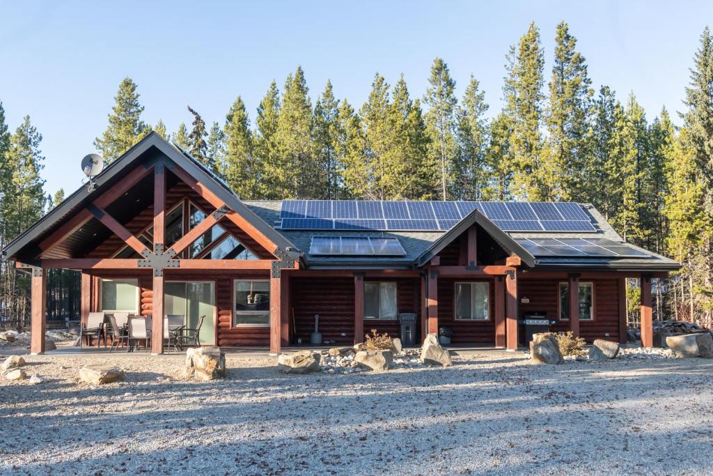 a log cabin with solar panels on the roof at Eagle Nest in Valemount