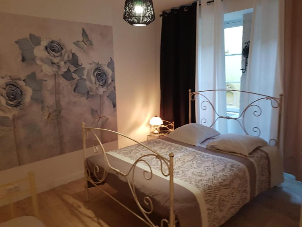 a bedroom with a bed and a painting of flowers at Fenêtre sur cour du Docteur Privey in Tournus