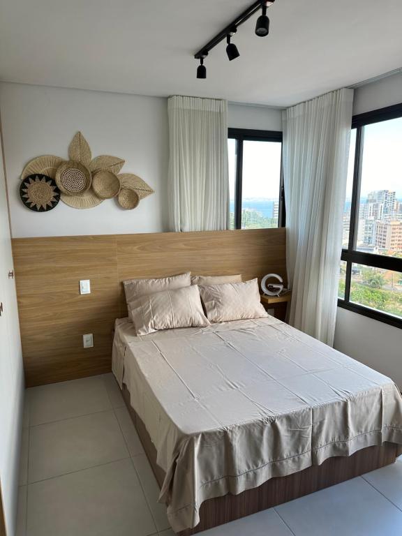 um quarto com uma cama grande num quarto com janelas em Coração de Salvador em Salvador