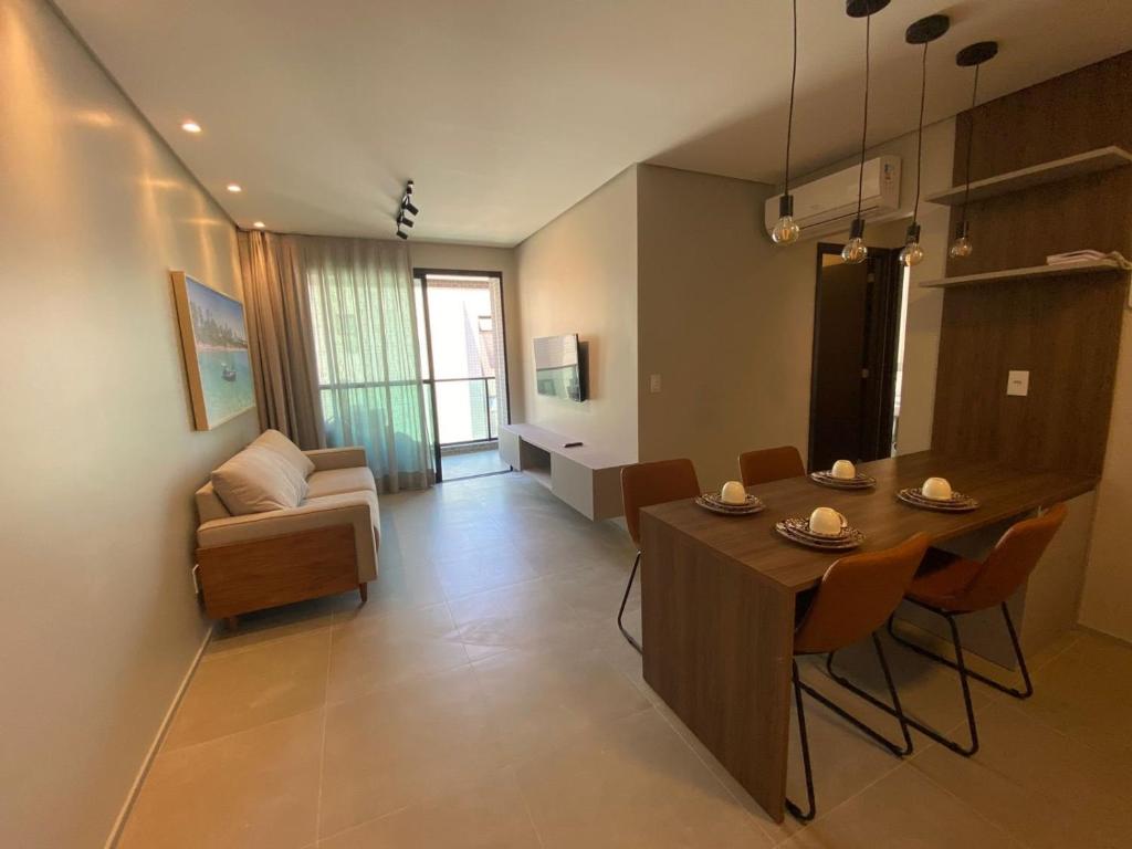 ein Wohnzimmer mit einem Tisch und Stühlen sowie ein Wohnzimmer in der Unterkunft Edificio Liv P.Verde Apto 1014-Mandi Hospitalidade in Maceió
