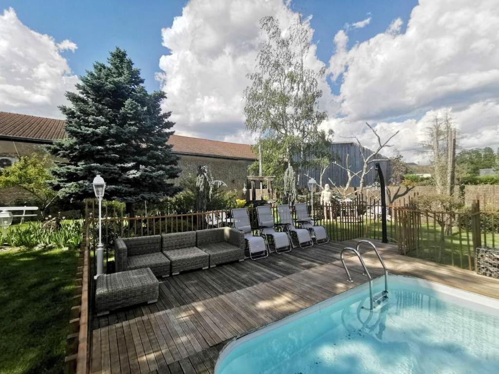 un cortile con piscina, divano e sedie di Villa de 4 chambres avec piscine privee jardin clos et wifi a Mont pres Chambord a Mont-près-Chambord