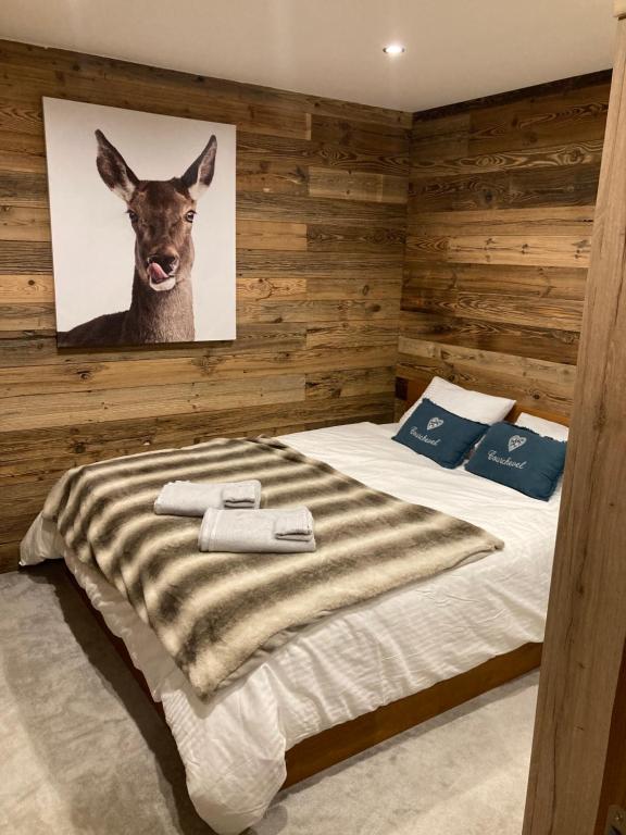 um quarto com uma cama com uma fotografia de um veado na parede em 1650 Moriond - 2 Double Bedroom near Snow Front em Courchevel
