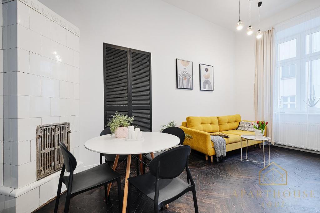 een woonkamer met een tafel en een gele bank bij Royal Style Apartment in Łódź