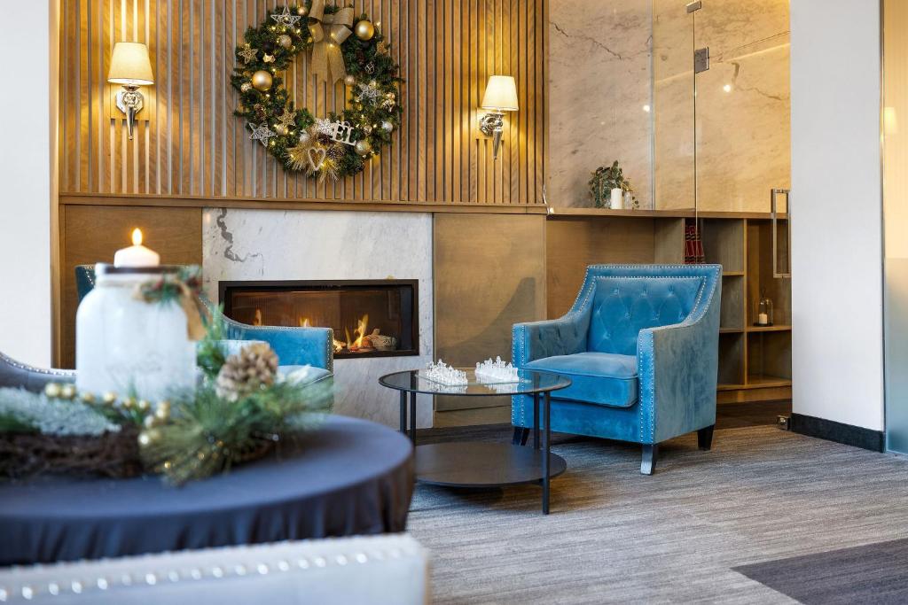 ケベック・シティーにあるホテル ポート-ロイヤルのロビー(青い椅子2脚、暖炉付)