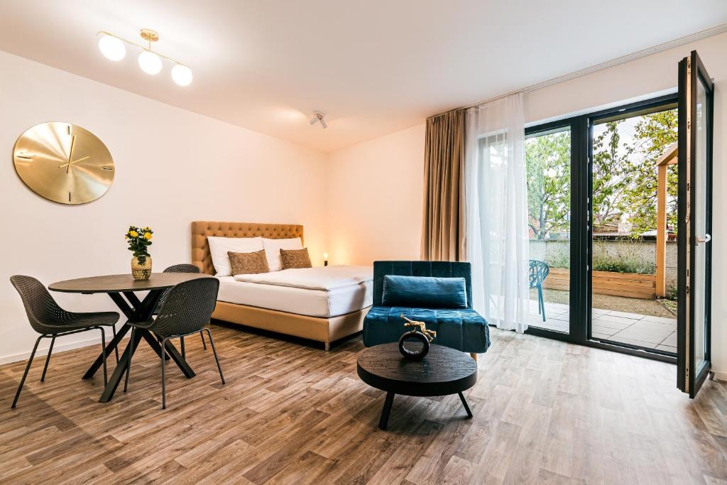 a hotel room with a bed and a table and a bed and a desk at Apartman Mikulov Garden in Mikulov