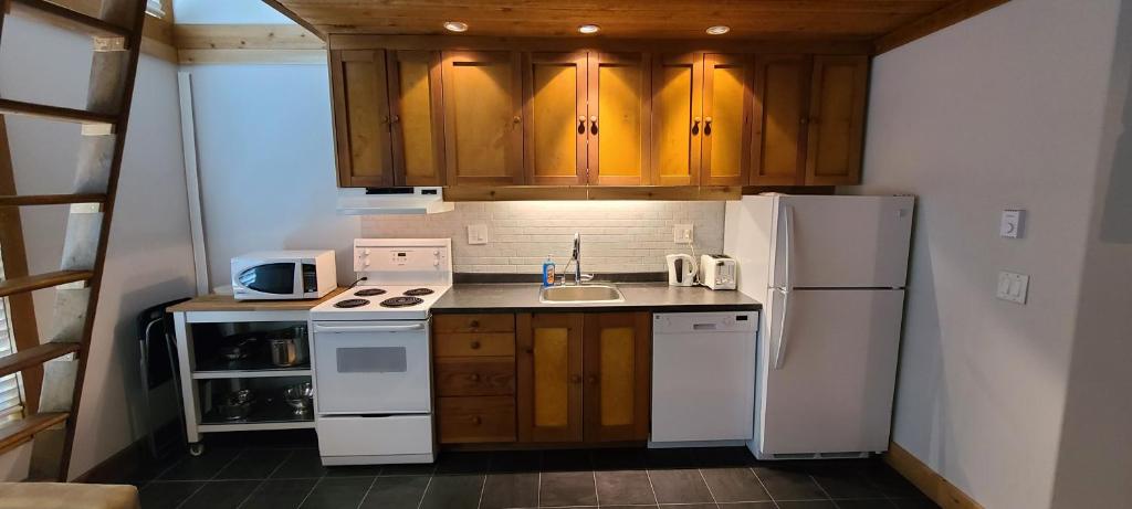 a kitchen with a white refrigerator and a sink at Gondola Village by Whistler Premier in Whistler