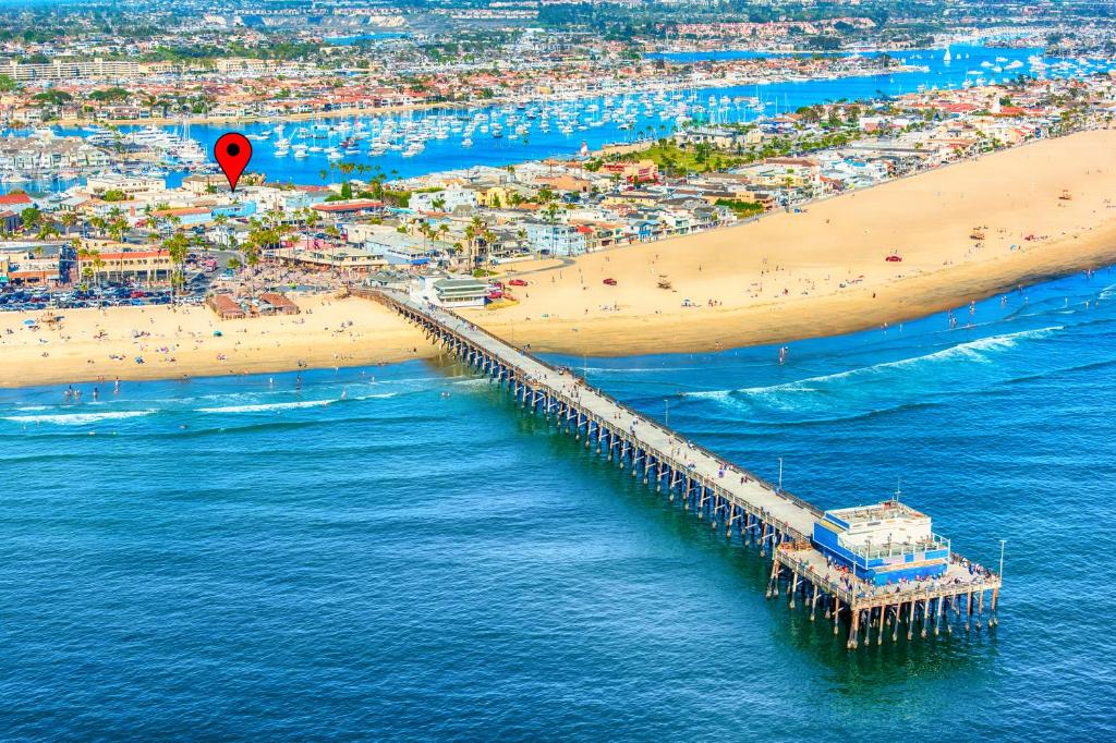 an aerial view of a beach with a pier and a hot air balloon at Newport Surf Casita in Newport Beach